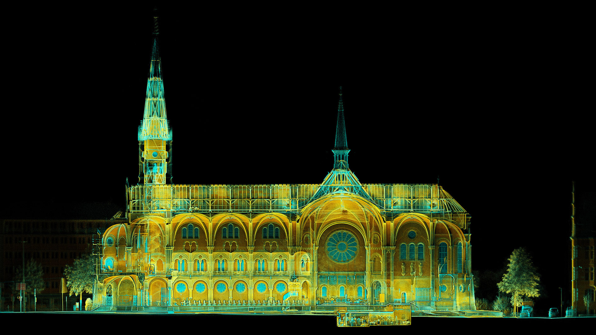 Digitalisierte Aufnahme der Johanneskirche, der Hintergrund sehr dunkel, die Strukturen des Gäbudes in Gelb-, Orange- und Blau-Tönen.