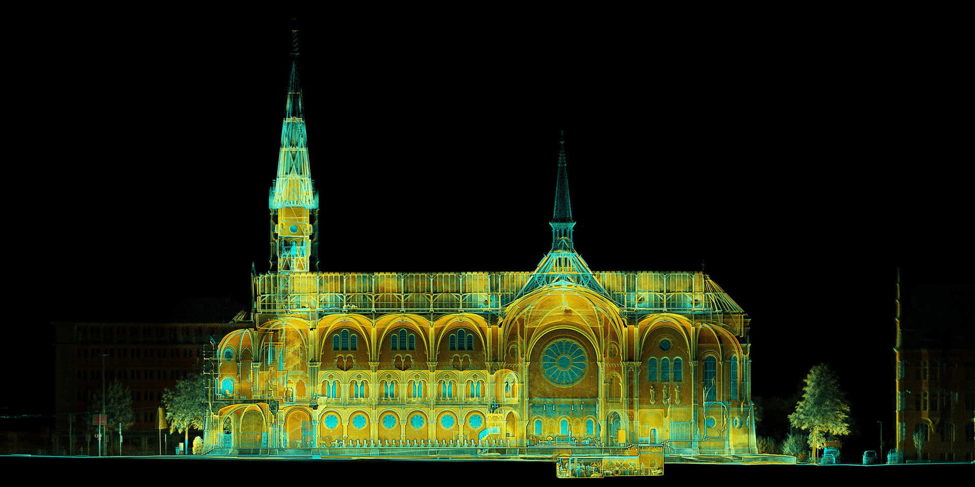 Digitalisierte Aufnahme der Johanneskirche, der Hintergrund sehr dunkel, die Strukturen des Gäbudes in Gelb-, Orange- und Blau-Tönen.