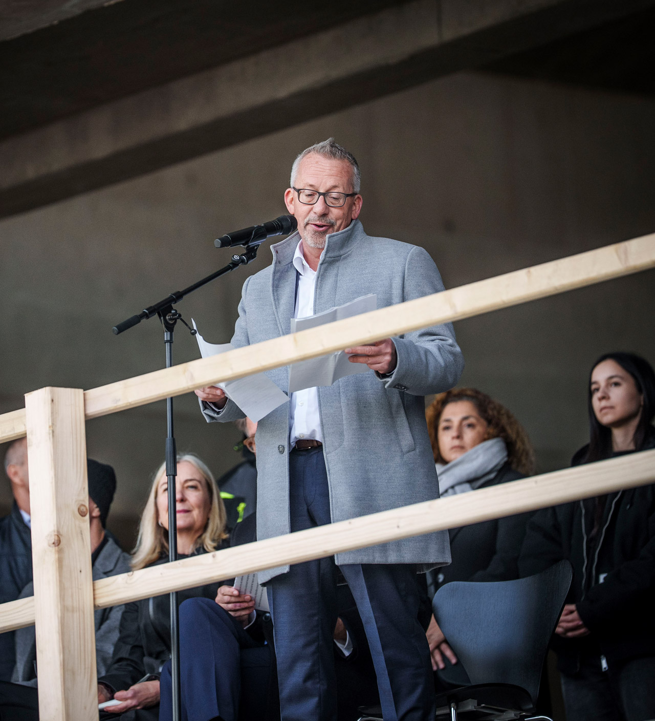 Christian Kaiser, Leiter des Bundesbaus Baden-Württemberg, hinter einem Mikrofon. Weitere Personen sitzen hinter ihm.