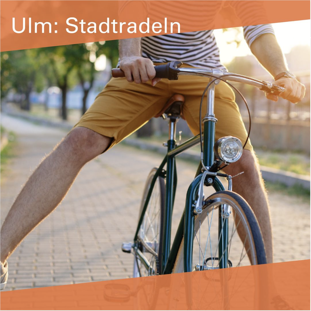 Ein Bildausschnitt mit einem blauen Fahrrad, der Fahrer ist nur bis zum Brustbein abgebildet und spreizt das rechte Bein ab.