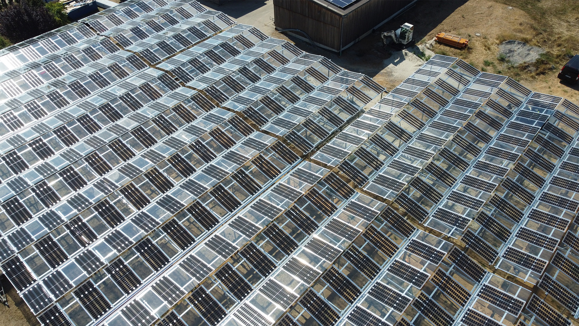 Eine Agri-PV-Anlage aus der Vogelperspektive: Es wechseln sich PV- und transparente Elemente ab.