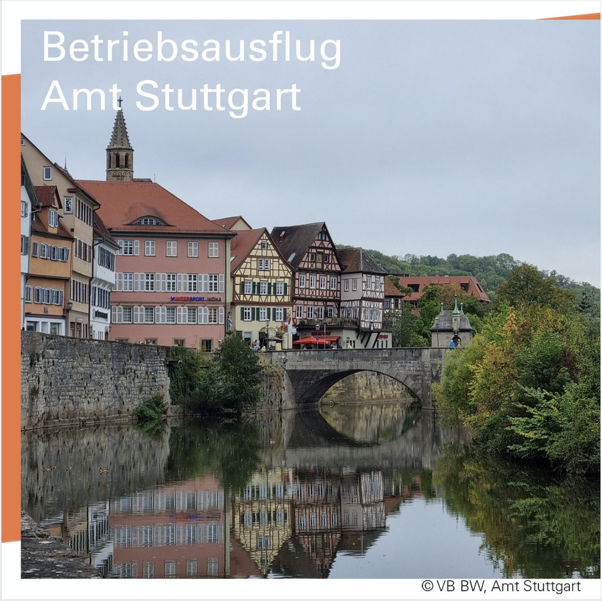 Ein Fluss mit einer steinernen Brücke, links Häuser, zum Teil Fachwerk, rechts Büsche und Bäume.