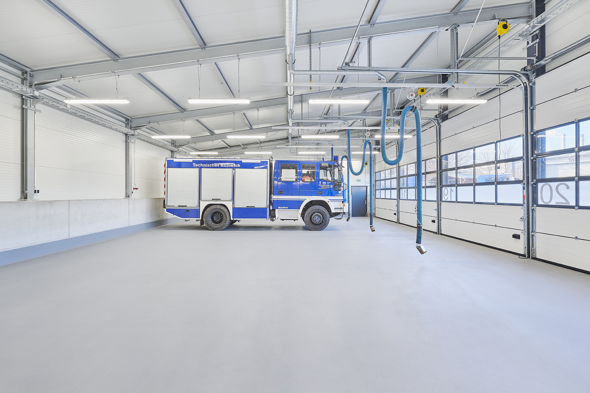 Eine große Garagenhalle, in er ein blau-weißer LKW des Technischen Hilfswerks steht.