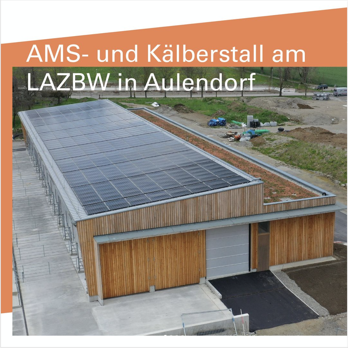 Ein Holzgebäude mit einer Stufe im Dach. Die obere Dachfläche ist mit PV-Modulen bestückt.